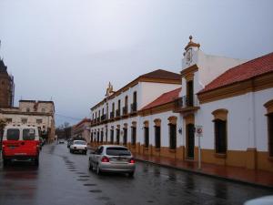 una strada cittadina con le auto e un edificio con torre dell'orologio di Humberto Apart A a Luján