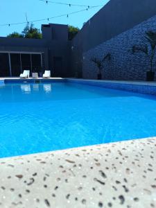 a large swimming pool with blue water at Residencia Dos Soles -Resistencia Chaco in Resistencia