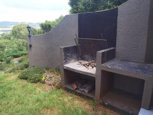 a stone wall with a fireplace on a hill at Brae Allen in Hartbeespoort