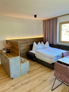Habitación de hotel con cama y escritorio en Apart Eder, en Schwendau