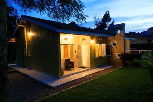 a green tiny house in a yard at night at JoyfulLiving - 300m to Victoria Mall, near Airport in Entebbe