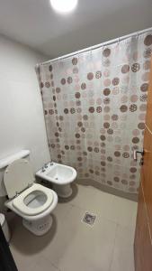a bathroom with a toilet and a shower curtain at Solares, Departamento zona centro in La Rioja