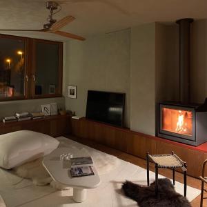 a living room with a fireplace and a tv at Appartement aan prachtig rivierenlandschap in Temse