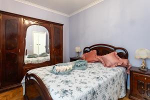 - une chambre avec un lit et un grand miroir dans l'établissement Casa Ze da Cotta Marisol, à Corroios