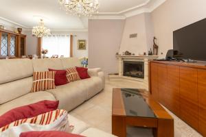 a living room with a couch and a tv at Casa Ze da Cotta Marisol in Corroios