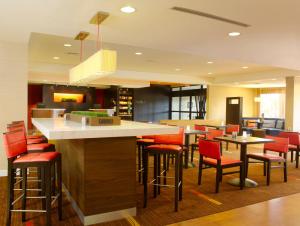 a bar with red chairs and tables in a restaurant at Courtyard Philadelphia/Langhorne in Langhorne