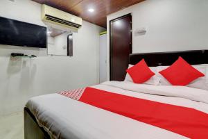 a bedroom with a large bed with red pillows at Hotel Memsaab Family Residency in Mumbai