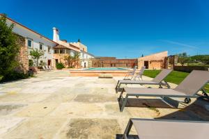 um pátio com 2 espreguiçadeiras e uma piscina em Quinta da Cortiça - Casa da Torre em Alvaiázere