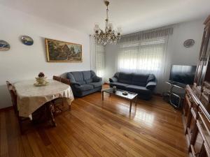 una sala de estar con 2 sofás azules y una mesa. en Apartamento Cuca en Baralla