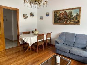 a living room with a table and a blue couch at Apartamento Cuca in Baralla