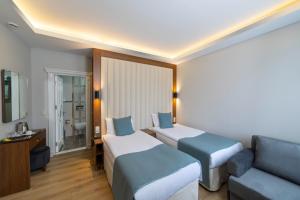 een hotelkamer met 2 bedden en een bank bij Hotel Black Tulip in Istanbul