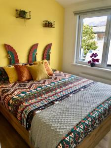 Un dormitorio con una cama con un edredón colorido y una ventana en Costa Linda B&B, en Vlissingen