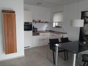 a kitchen with a dining table and a kitchen with white cabinets at 2 Zimmer Ferienwohnung mit Seeblick in Überlingen in Überlingen