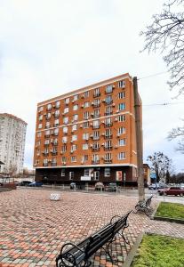 een groot gebouw met twee banken ervoor bij Миниотель в Харькове, ЮЖД in Charkov