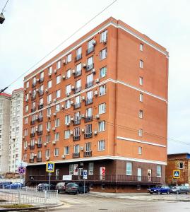 a large brick building with cars parked in front of it at Миниотель в Харькове, ЮЖД in Kharkiv