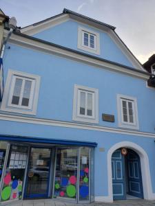 un edificio azul con ventanas y puertas en Andrea en Mürzzuschlag