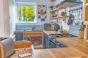 a kitchen with a sink and a stove and a window at Couples getaway in central Windermere, ground floor flat with parking in Windermere