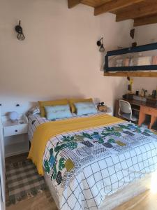 1 dormitorio con 1 cama con colcha amarilla en Casa las montañas de Anaga, en La Laguna