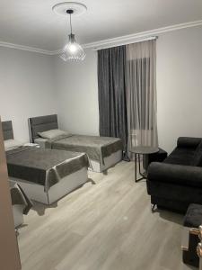 Habitación de hotel con 2 camas y sofá en Hostel Divan, en Ereván