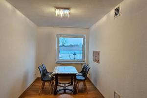 uma sala de jantar com uma mesa e cadeiras e uma janela em An apartment located at nature with 2.5 rooms em Dusseldorf
