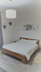 Ce lit se trouve dans un dortoir blanc doté d'une lampe. dans l'établissement Accogliente Bilocale In Zona Centrale - alloggio uso turistico - VDA - Aosta - 0318, à Aoste