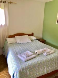 una camera da letto con un letto e due asciugamani di Pousada Pinho Verde a Monte Verde