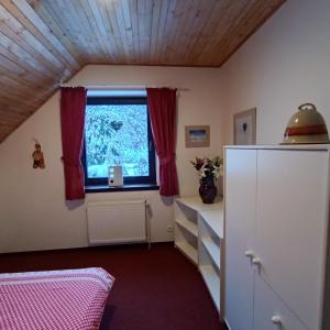 ハルラホフにあるApartmány Nový Svět 548のベッドルーム1室(赤いカーテン付きの窓、ドレッサー付)