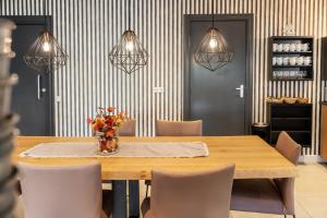 a dining room table with chairs and a vase of flowers at Hotel In den Brouwery in Domburg