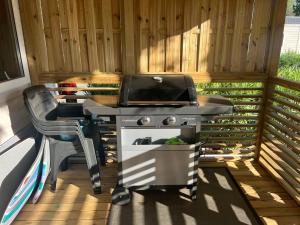 a grill and a chair on a patio at Mobilhome Camping la Carabasse Vias in Vias
