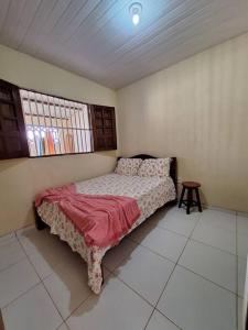 a bedroom with a bed with a red blanket on it at Casa de Avinha in Sirinhaém