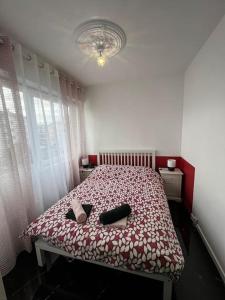 a bedroom with a bed with a red and white bedspread at Appartement t2 in Vénissieux