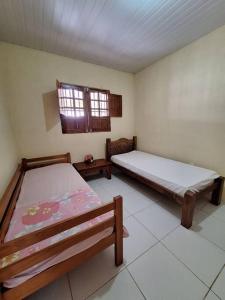 a bedroom with two beds and a window at Casa de Avinha in Sirinhaém