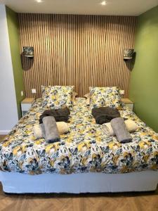 uma cama grande com almofadas num quarto em Le cocon des cigognes em Dieppe