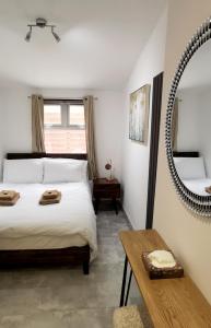 Luxury London house sleeps 13, 2 minutes to metro في لندن: غرفة نوم بسرير ومرآة وطاولة