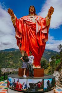 deux personnes debout devant une statue dans l'établissement AVANI HOSPEDAJE, à Lligua