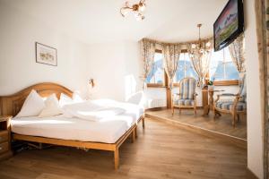 pokój hotelowy z dwoma łóżkami i telewizorem w obiekcie Turmhotel Gschwendt w mieście Valle di Casies