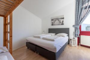 een slaapkamer met een groot bed met witte lakens bij AmicitiA in Lemmer