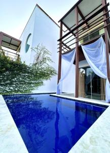 a villa with a swimming pool in front of a house at La Reserve Villa Tropicana in Pipa
