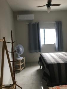 Schlafzimmer mit einem Bett, einem Ventilator und einem Fenster in der Unterkunft Pousada São Pedro in Aracruz