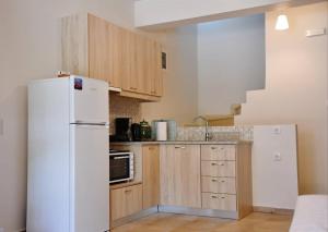 a kitchen with a white refrigerator and wooden cabinets at Christina's Seaside in Afissos