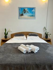 1 dormitorio con 1 cama con toallas en Vila TIARA Costinesti, en Costinesti