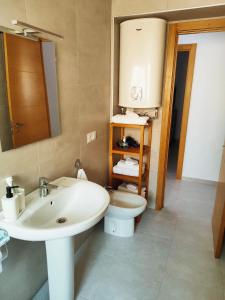 a bathroom with a sink and a toilet and a mirror at Apartamento en Torre del Mar in Torre del Mar