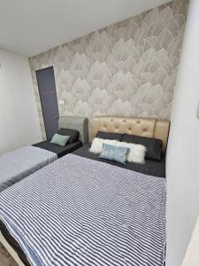 1 dormitorio con 2 camas y pared en Charming 3BR Podium 7pax Walk to Aeon, en Kuching