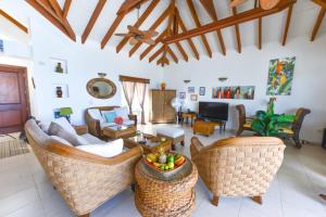 a living room with a couch and chairs at Villa Jambalaya in Maho Reef