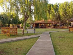 une passerelle dans un parc avec des bancs et un pavillon dans l'établissement CABAÑAS VALLE LUNLUNTA, à Maipú