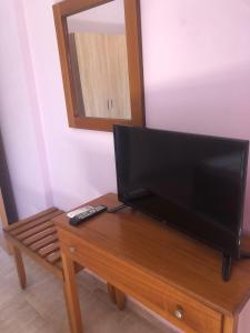 a television on a wooden table with a remote control at Katerina's SeaSide in Afissos