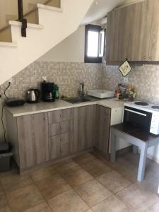 a kitchen with wooden cabinets and a sink and a stove at Katerina's SeaSide in Afissos
