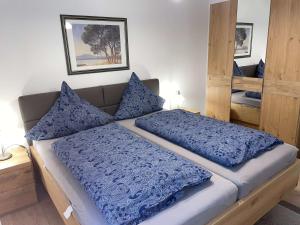 a bedroom with a large bed with blue comforter and pillows at Einfach entspannen in Arrach