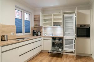 a kitchen with white cabinets and an empty refrigerator at Annalena in Schwerin