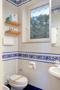 a bathroom with a toilet and a sink and a window at Villa il Turro in Massa Lubrense +71 photos
